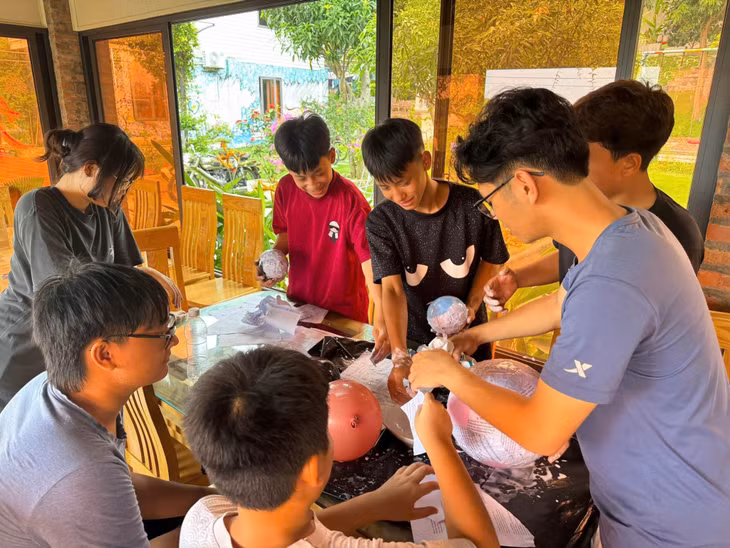 Các tình nguyện viên hướng dẫn các em học sinh làm mô hình hành tinh trong dải Ngân hà.
