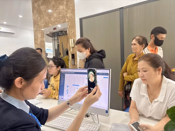 Nhân viên MobiFone hỗ trợ xác thực thông tin cho khách hàng trong ngày 15-6 - Ảnh: HÀ VI