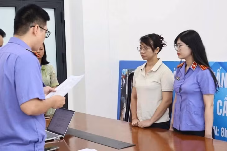 Cơ quan tố tụng tống đạt lệnh khởi tố, bắt tạm giam đối với nguyên kiểm sát viên Lê Thị Hồng Nhung - Ảnh: V.P.
