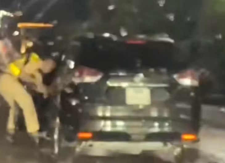 Thời điểm xảy ra sự việc tài xế điều khiển xe kéo lê một chiến sĩ cảnh sát trên đường. Ảnh: Cắt từ video người dân cung cấp