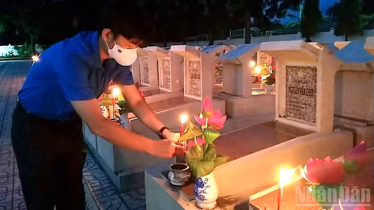 Đoàn viên Cà Mau thắp nến tri ân tại Nghĩa trang liệt sĩ tỉnh. (Ảnh HỮU TÙNG)
