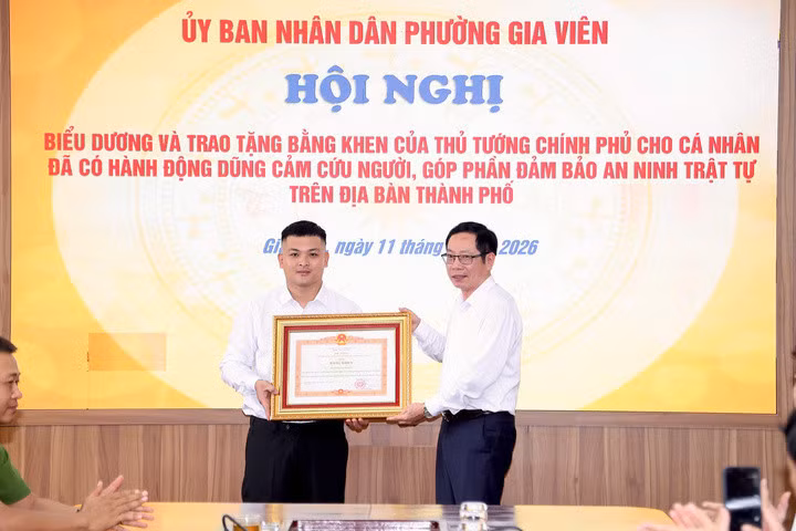 Ông Vũ Tiến Phụng, Phó Chủ tịch UBND TP Hải Phòng trao Bằng khen của Thủ tướng và tặng hoa chúc mừng anh Phạm Thế Huy Hoàng.