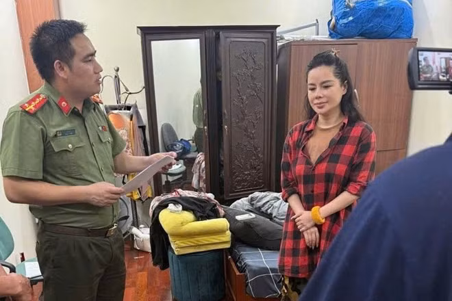 Cán bộ Cơ quan An ninh điều tra - Công an TP Hà Nội đọc lệnh khám xét nơi ở của đối tượng Nguyễn Thiên Hương. Ảnh: Công an Hà Nội