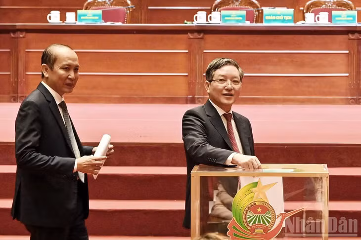 Chủ tịch Hội Nông dân Việt Nam khóa VIII Lương Quốc Đoàn (bên phải) bỏ phiếu tại phiên làm việc.