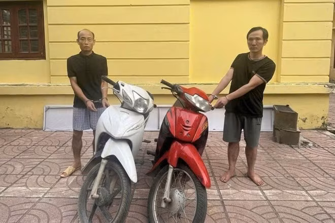 Đối tượng Vũ Xuân Ngọc (bên trái) và Hoàng Minh Đức (bên phải) cùng 2 chiếc xe máy là tang vật vụ án. Ảnh: Công an TP Hà Nội