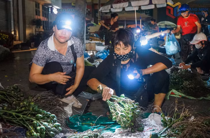 Thiếu ánh sáng, nhiều tiểu thương mang theo đèn pin để kiểm tra kỹ chất lượng hàng trước khi nhập.