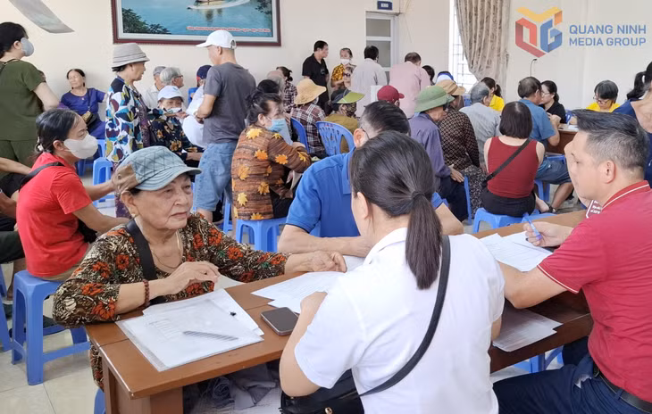 Bà Đặng Thị Tươi, ở Khu 7, phường Cao Xanh được cán bộ BHXH tỉnh hướng dẫn chi trả lương hưu thông qua tài khoản ATM.