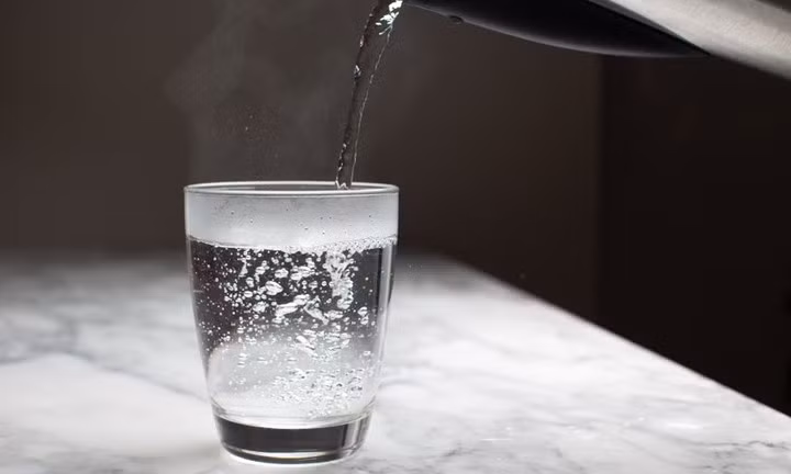 Nhiệt độ từ nước ấm giúp làm mềm lớp keo bị đông ở gần miệng chai và hỗ trợ các phân tử keo trở nên linh hoạt hơn. (Ảnh minh họa)