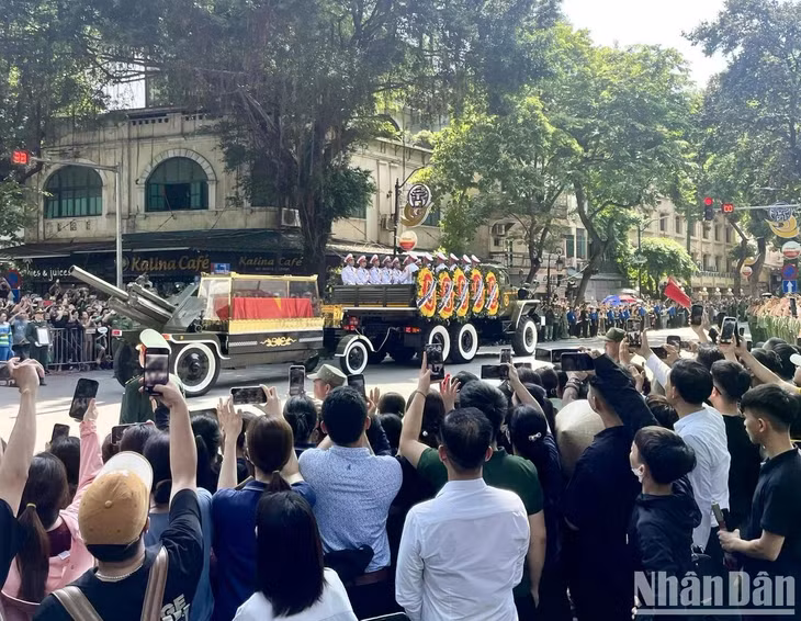 Đoàn xe chở linh cữu của Tổng Bí thư Nguyễn Phú Trọng đi qua phố Hàng Khay trong niềm tiếc thương, xúc động của người dân. (Ảnh: ĐÌNH TUẤN)