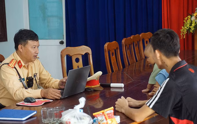 Cảnh sát giao thông cửa ô Hòa Hiệp hỏi thăm gia đình anh Duy trước khi hỗ trợ về quê. Ảnh: Văn Hồ