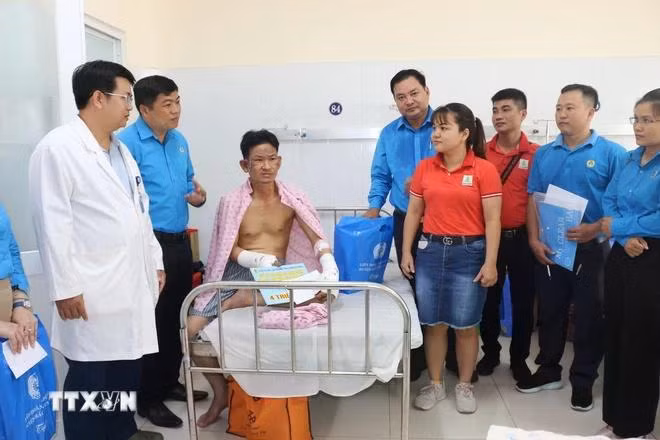 Đại diện Liên đoàn Lao động tỉnh Bình Dương thăm hỏi, động viên công nhân bị tai nạn lao động. (Ảnh: TTXVN phát)