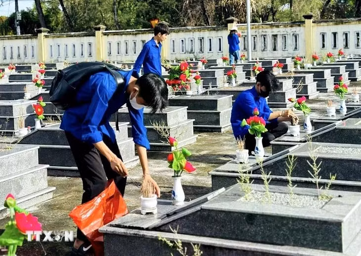 Đoàn viên thanh niên sửa sang, làm mới phần mộ các Anh hùng liệt sỹ tại nghĩa trang liệt sỹ các địa phương của tỉnh Quảng Nam. (Ảnh: TTXVN phát)