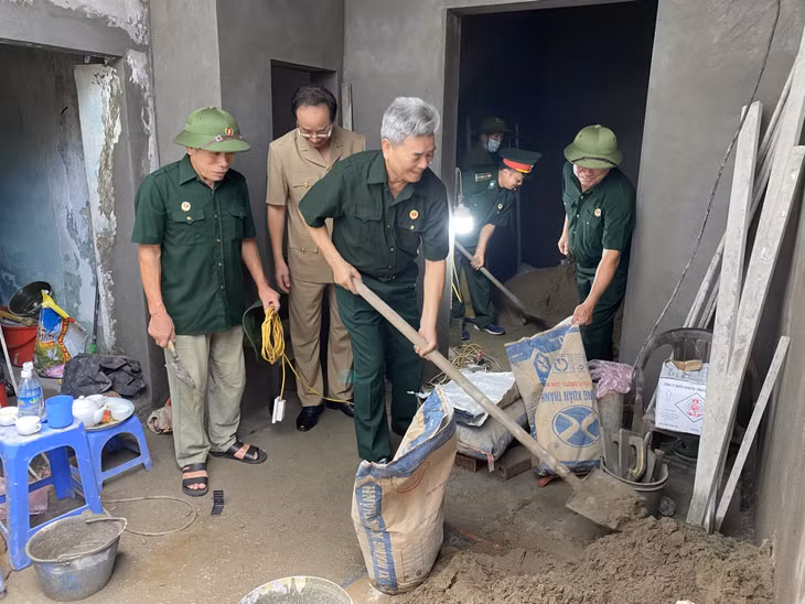 Thương binh hạng 2/4 Vũ Tiến Thanh (người cầm xẻng) cùng các CCB khu 4, phường Trần Hưng Đạo (TP Hạ Long) giúp đỡ gia đình hộ khó khăn xây nhà.