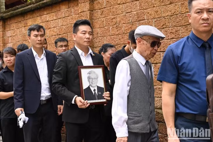 Nhiều người đã mang theo di ảnh của Tổng Bí thư trên hành trình viếng.