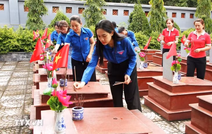 Đoàn viên thanh niên thị trấn Yên Châu (Yên Châu, Sơn La) thắp hương tưởng nhớ các Anh hùng liệt sỹ tại Nghĩa trang Liệt sỹ huyện. (Ảnh: Quang Quyết/TTXVN)