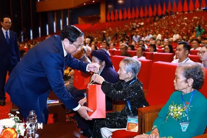 Thủ tướng Phạm Minh Chính tặng quà tri ân người có công với cách mạng. (Ảnh: Dương Giang/TTXVN)
