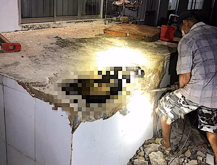 Đập bồn chứa nước để đưa thi thể ra ngoài khám nghiệm. Ảnh: Duy Tuấn