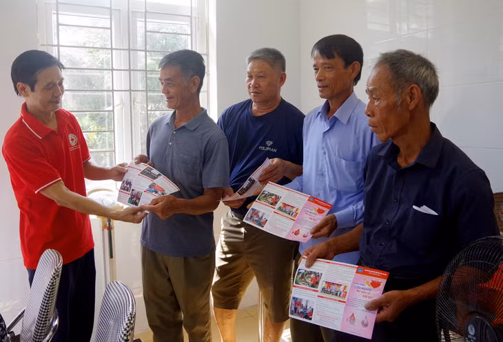Cán bộ Hội Chữ thập đỏ tỉnh phát tờ rơi tuyên truyền phòng chống dịch bệnh cho các đối tượng chính sách.