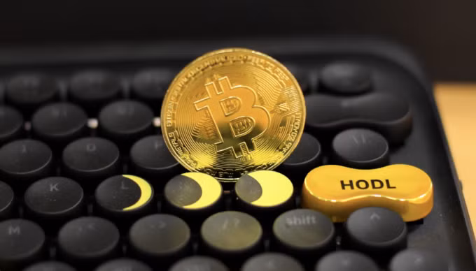 Một đồng xu có biểu tượng Bitcoin đặt trên bàn phím. Ảnh: Khương Nha