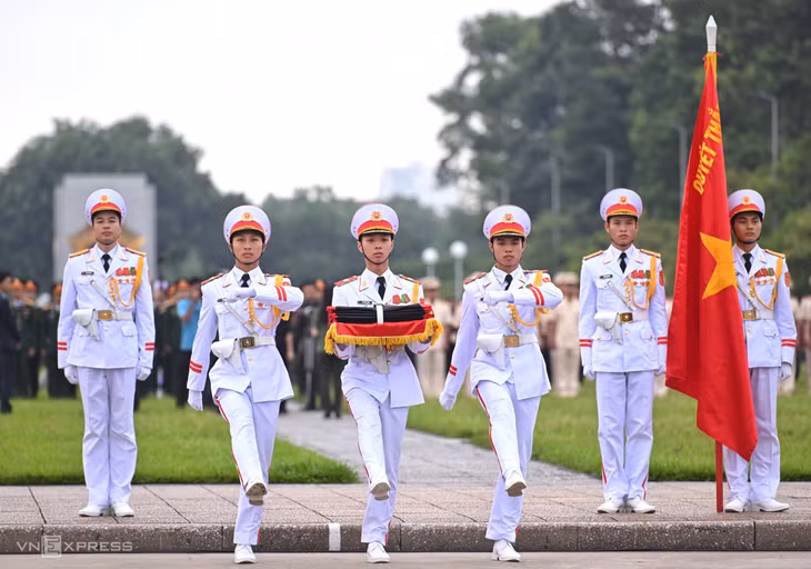 Quốc kỳ gắn dải băng tang màu đen, được tiêu binh mang vào.