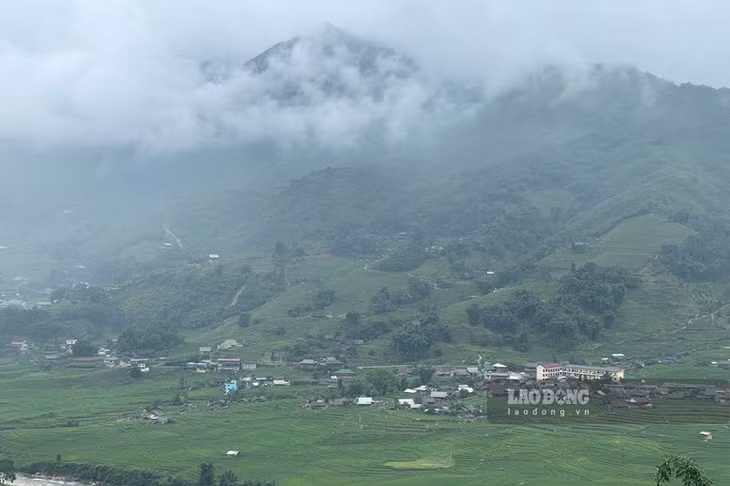 Dưới chân núi, ngôi làng của người H'Mông thoát ẩn, thoát hiện giữa mây mù mờ ảo.