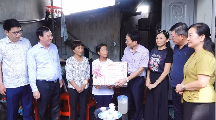 Đồng chí Nguyễn Mạnh Tuấn, Giám đốc Sở Xây dựng trao quà cho cháu Cám Mai Hoa, ở thôn Đông Thành, xã Đông Xá.