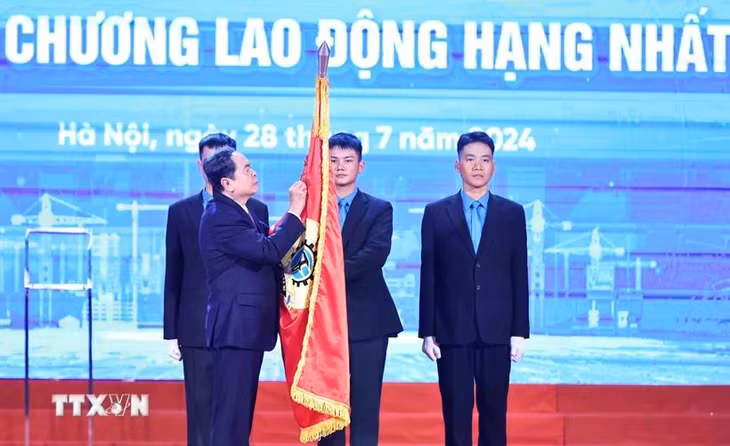Chủ tịch Quốc hội Trần Thanh Mẫn gắn Huân chương Lao động hạng Nhất lên cờ truyền thống của Tổng Liên đoàn Lao động Việt Nam. (Ảnh: Minh Đức/TTXVN)
