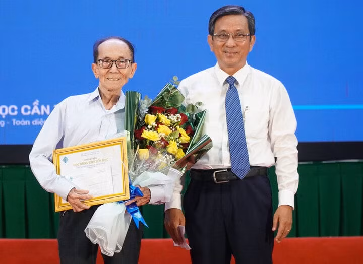 PGS.TS Trần Trung Tính, Hiệu trưởng Trường Đại học Cần Thơ trao học bổng "Người cao tuổi có tinh thần học tập suốt đời" cho ông Nguyễn Tấn Thành. Ảnh: Hoài Thanh