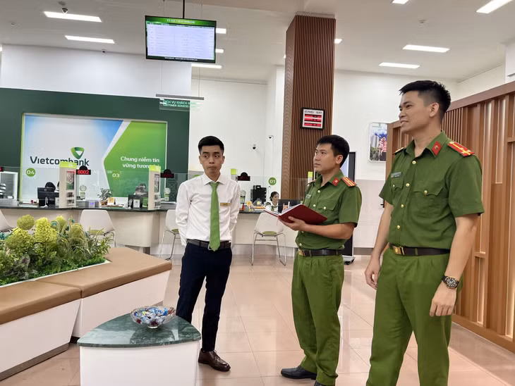 Thiếu tá Nguyễn Sùng Nãm (đứng giữa) cùng cán bộ đơn vị kiểm tra hoạt động của thiết bị tín hiệu báo động khẩn cấp tại Vietcombank chi nhánh Hạ Long.