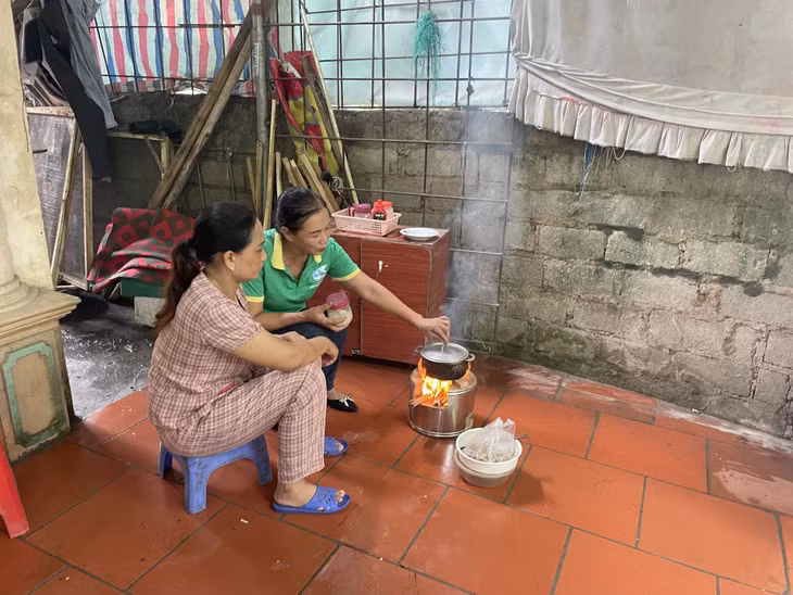 Chị Nguyễn Thị Dung (thôn 15, xã Hạ Long, huyện Vân Đồn) (bên trái) được cán bộ Chi hội phụ nữ thôn hướng dẫn cách sử dụng bếp đun tiết kiệm năng lượng.