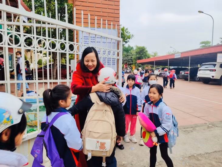Cô giáo Nguyễn Bích Thủy đón học sinh mỗi buổi sáng tại cổng trường học.