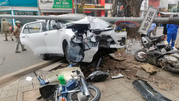 Xe tô tô lao lên vỉa hè tông gãy trụ đèn và nhiều xe máy.