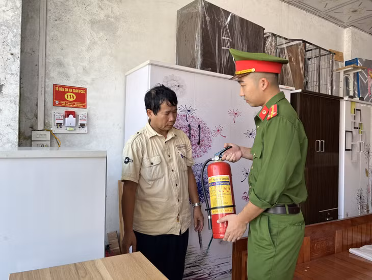 Cảnh sát PCCC&amp;CNCH (Công an TP Cẩm Phả) hướng dẫn cách sử dụng bình chữa cháy cho người dân khu Nam Sơn 2.
