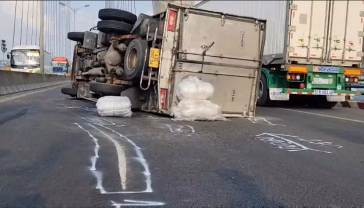 Chiếc xe tải chở nước giải khát bị nổ lốp rồi lật ngang giữa cầu Cần Thơ.