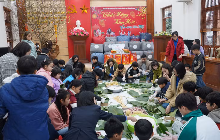 Các cán bộ, đoàn viên tham gia hoạt động gói bánh chưng cùng các em nhỏ.
