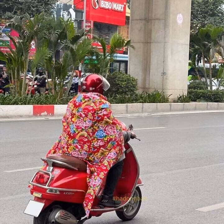Hình ảnh người đàn ông quấn quanh người chiếc chăn con công cưỡi xe LX tại quận Hà Đông, Hà Nội được chia sẻ khắp các diễn đàn mạng. (Ảnh: Hà Đông Bản)