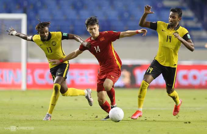 Hoàng Đức (đỏ) trong trận đấu Malaysia tại vòng loại World Cup 2022. Ảnh: Lâm Thoả