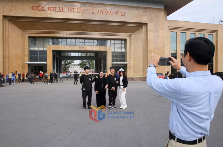 Du khách chụp ảnh lưu niệm tại Cửa khẩu quốc tế Móng Cái sau khi hoàn tất thủ tục XNC.