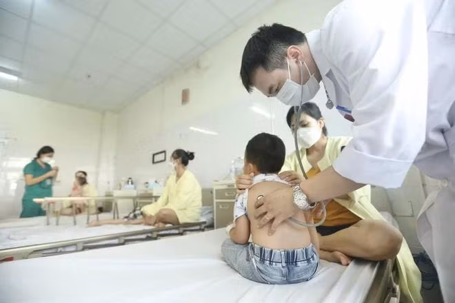 Bác sỹ khám, theo dõi sức khỏe cho trẻ mắc cúm A. (Ảnh: Minh Quyết/TTXVN))