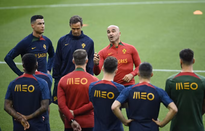 HLV Roberto Martinez (áo đỏ phải) phổ biến cho Ronaldo (ngoài cùng trái) và các cầu thủ Bồ Đào Nha trước trận bảng A vòng loại Euro 2024 gặp Slovakia. Ảnh: AFP