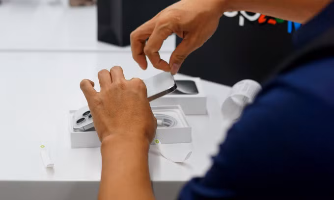 Một người mở hộp iPhone 15 Pro Max trong ngày đầu bán tại Việt Nam đêm 29/9. Ảnh: Lưu Quý