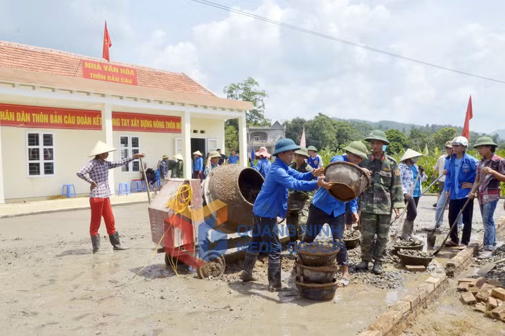 Người dân xã Lục Hồn tham gia đổ bê tông sân nhà văn hóa thôn Bản Câu. Ảnh: Phương Thúy