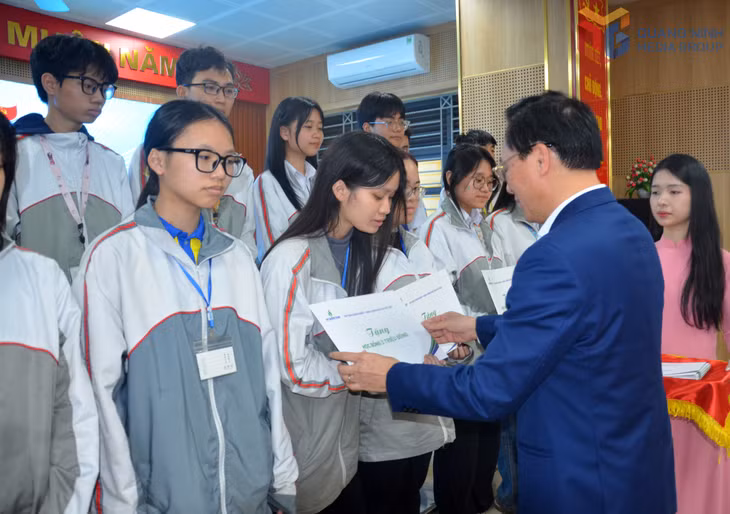Đồng chí Bùi Minh Tiến, thành viên Hội đồng thành viên Tập đoàn Công nghiệp - Năng lượng Quốc gia Việt Nam tặng học bổng cho các học sinh.