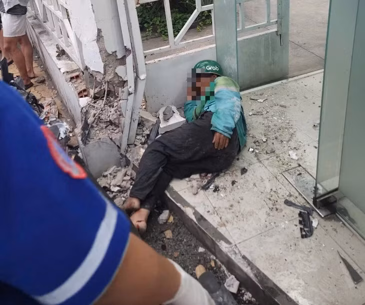 Một người đàn ông chạy xe ôm công nghệ bị xe ủi văng xa khoảng 10m - Ảnh: MINH HÒA