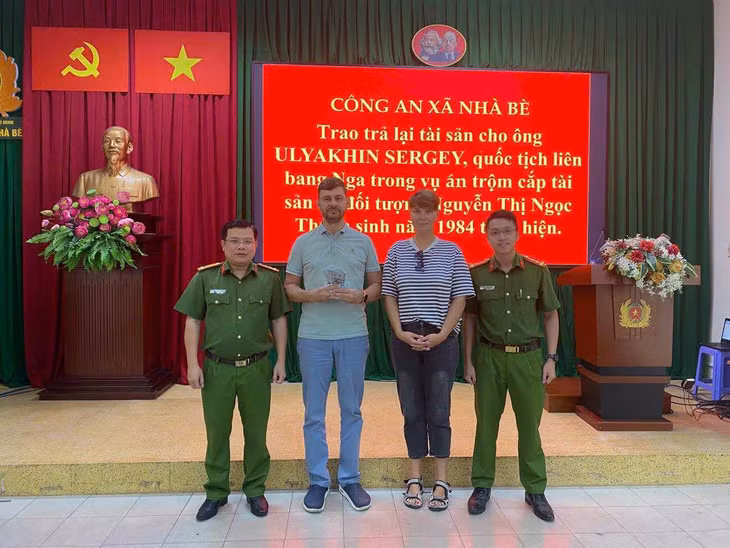Công an trao trả tài sản bị trộm cho vợ chồng người Nga. Ảnh: Công an xã Nhà Bè