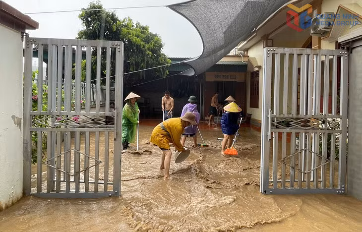 Người dân khu Bắc Sơn 5, phường Vàng Danh dọn bùn, nước ra khỏi nhà ở do ngập lụt sau mưa lớn. Ảnh: Minh Đức