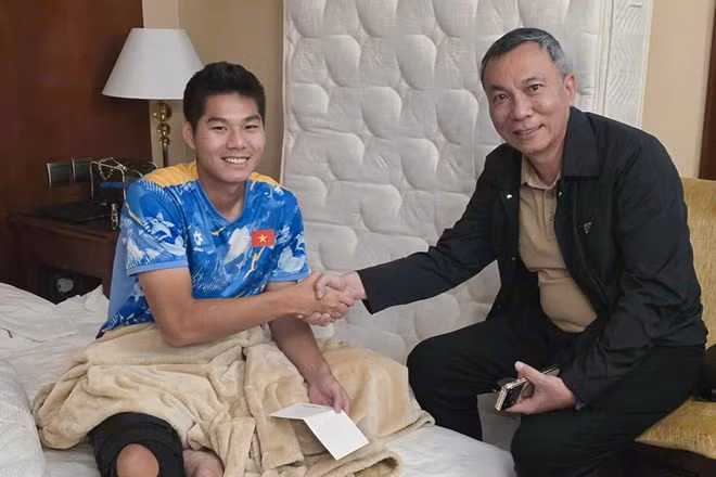 Chủ tịch VFF Trần Quốc Tuấn động viên trung vệ Nguyễn Hiểu Minh sau ca cấn thương nặng. Ảnh: VFF