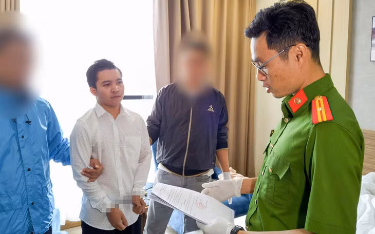 Công an đọc lệnh bắt bị can Nguyễn Trần Khánh Huy - Ảnh: CA cung cấp