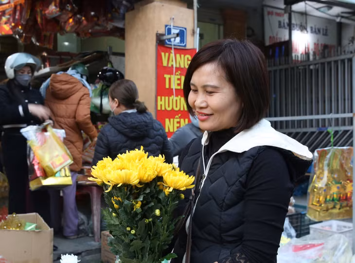 Người dân chọn bó hoa đẹp dâng lên ban thờ cúng tất niên và chào đón năm mới.