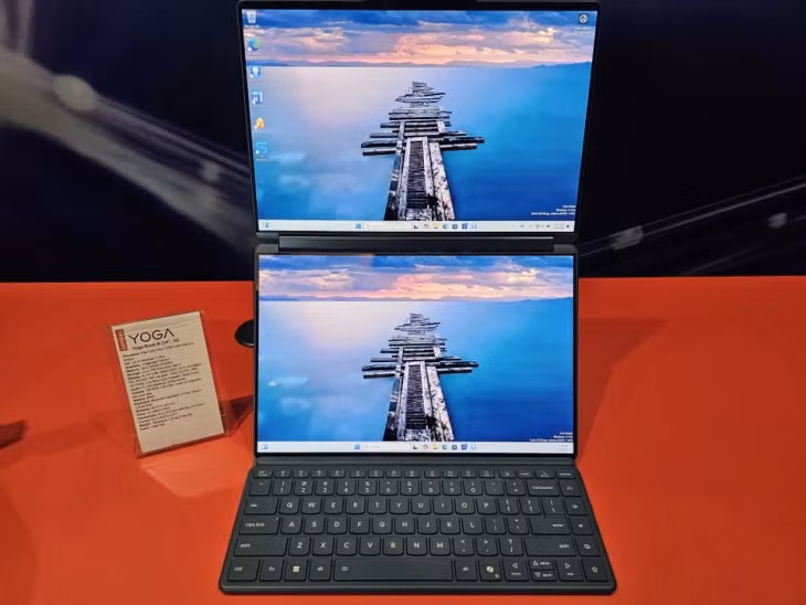 Tăng kích thước laptop 2 màn hình. Trong dòng laptop Yoga thế hệ thứ 10 của Lenovo, Yoga Book 9i nổi bật với kích thước 2 màn hình tăng lên 14 inch (thế hệ trước là 13 inch), độ phân giải 2,8K, tần số quét 120 Hz và độ sáng tối đa 750 nit. Sản phẩm trang bị chip xử lý Intel Core Ultra 7 255H, RAM tối đa 32 GB, SSD tối đa 1 TB, cổng Thunderbolt 4 và Wi-Fi 7. Loạt tính năng AI trên thiết bị gồm Smart Note để ghi chú, app đọc sách Smart Reader, điều khiển cử chỉ và trợ lý Microsoft Copilot. Ảnh: PC World.